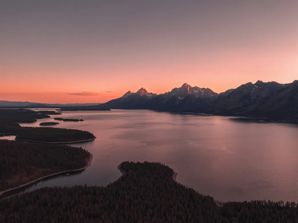 Mountain lake and rugged peaks at sunset in Wyoming